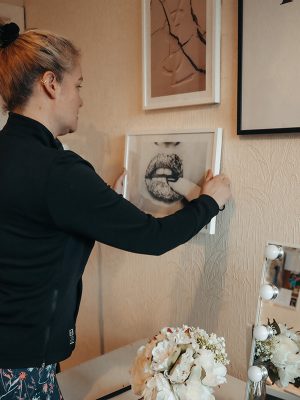 Image of a piece of art being hung on a wall as part of building a gallery wall
