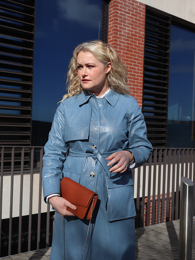 Lorna Weightman wearing a blue trench coat holding a brown small bag international womens day round up