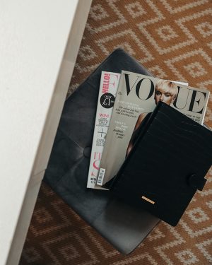 Image of grey box seat with magazines and a black personal diary placed on top