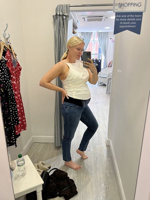 Lorna Weightman taking picture in front of a mirror wearing a white top and blue jeans